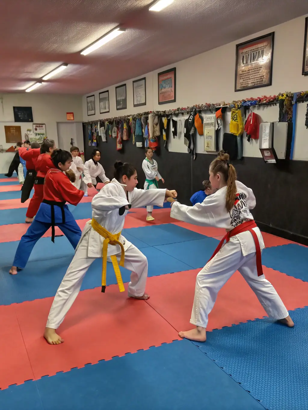 A group of karate students of all ages and skill levels, bowing respectfully to their instructor at the end of a class at TRADITION KARATE OUEST.